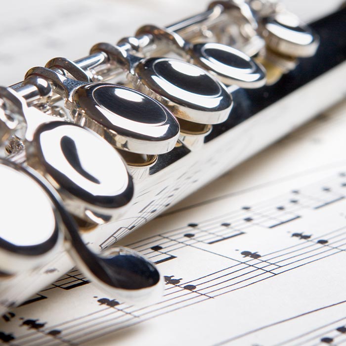 A flute rests atop sheet music